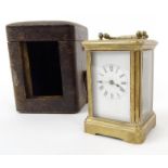 Miniature brass carriage clock housed in original leather carrying case, 8cm high excluding the