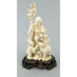 Well detailed oriental Chinese ivory figure of an elder with child on a carved wooden base, 20cm