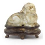 Small carved jade Buddhistic lion on a hardwood stand, 4cm wide : For Condition Reports please visit