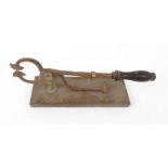 Victorian cast iron and brass sugar cane cutter mounted on a wooden base, 30cm wide : For