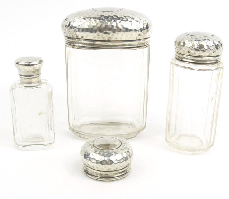 Three glass bottles with silver lids and one other silver lid - three by Alex B. Clark with