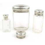 Three glass bottles with silver lids and one other silver lid - three by Alex B. Clark with