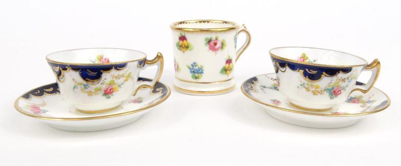 Two miniature Royal Crown Derby porcelain cups and saucers hand painted with flowers, together