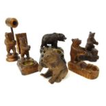 Six Black Forest wooden carved bears including a pipe-holding example and a wooden carved bear match