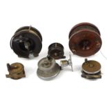 Selection of wooden, brass and aluminium fishing reels including a swivel trout reel, the largest