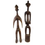 Two large African tribal carved wooden fertility figures - one with a beaded waistband, the larger