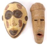 Two African carved wooden tribal masks - one with a white painted face, the larger 39cm high : For