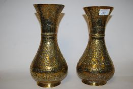 A pair of early 20th century hammered Indian brass vases having decorative animal scene designs with