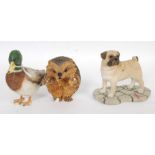 A collection of three vintage ceramic figures including a hedgehog, pug dog and a mallard duck.