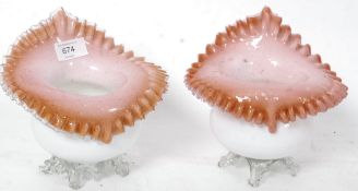 A pair of early 20th century vaseline glass vases having milk glass bodies with pink interiors