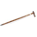 A good tribal walking stick with carved inlaid twin wood detailing having bone teeth alligator