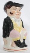 A large late 19th century Staffordshire toby jug being decorated and glazed with handle to rear.