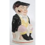 A large late 19th century Staffordshire toby jug being decorated and glazed with handle to rear.