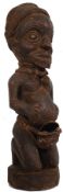 An African Naga / Assam tribal fertility statue having roped conch shell to centre being raised on a