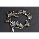 A silver charm bracelet having charms to