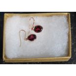 A pair of 9ct gold oval drop earrings inset with garnet stones, weight 1.