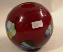 A 20th century studio glass vase in deep red, with colourful bursts to the sides.