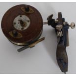 A vintage early 20th century wooden fishing reel being unnamed together with a small metal