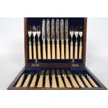 A mahogany cased set of silver hallmarked collar knives and forks with baize lined interior.