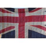 An old large vintage panel stitched Union Jack flag having rope and toggle ends.