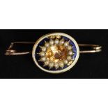 Gold brooch made from a necklace snap set with enamel pearls with central golden topaz stone.