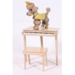 A vintage 1950's childs piano and stool in original finish together with a bendy composite dog.