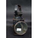 An early 20th century railway lamp / lantern with glass lens to front,