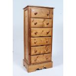 A 20th century antique style tall pedestal chest of drawers having a flared top, raised on bun feet,