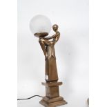 An Art Deco style bronze effect lamp with globe shade to top on a square plinth base.