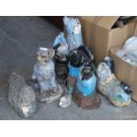 A collection of well weathered reconstituted gnomes and other garden ornaments