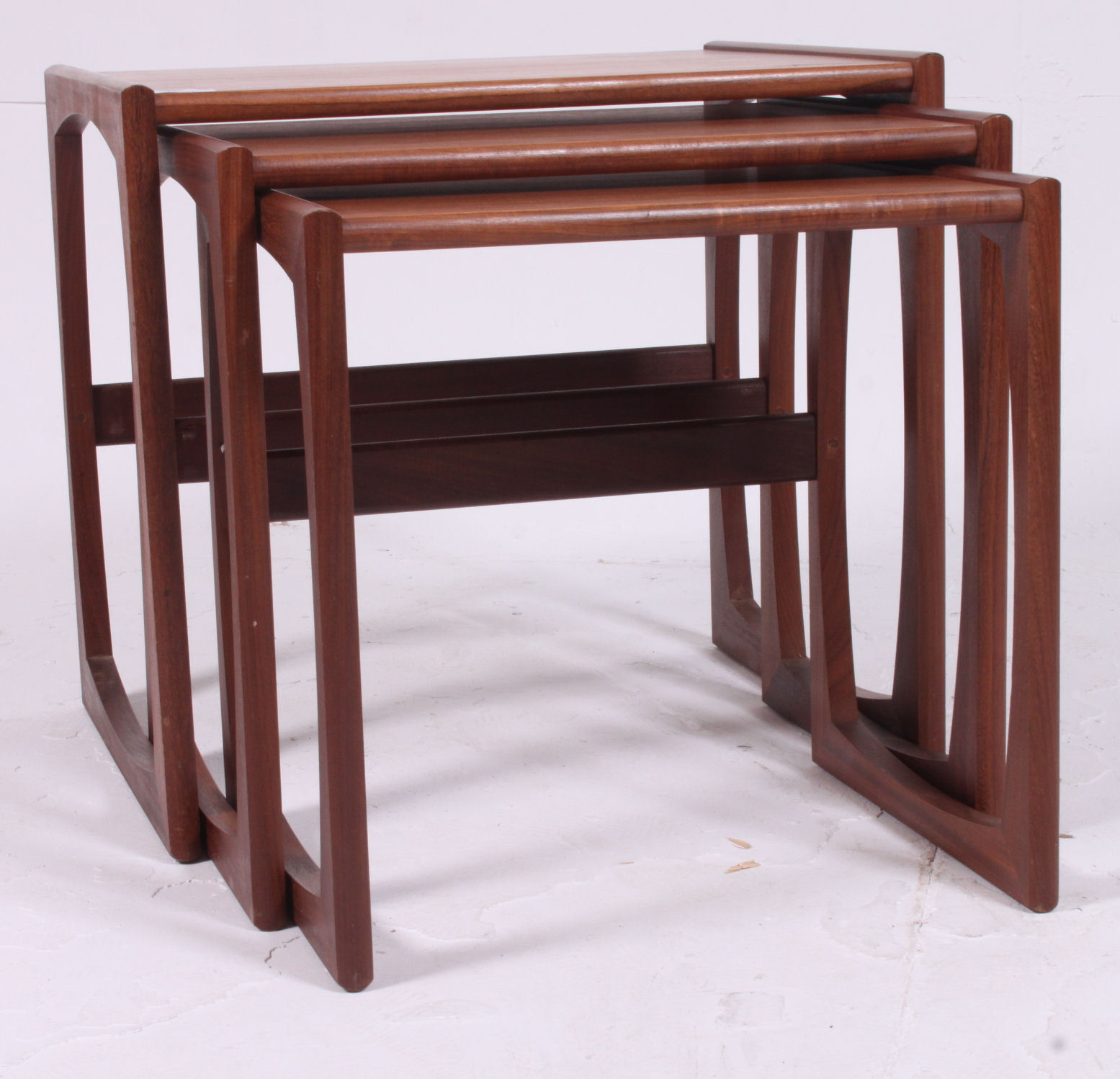A 1970's G-Plan Kelso pattern retro teak wood nest of tables raised on shaped supports with