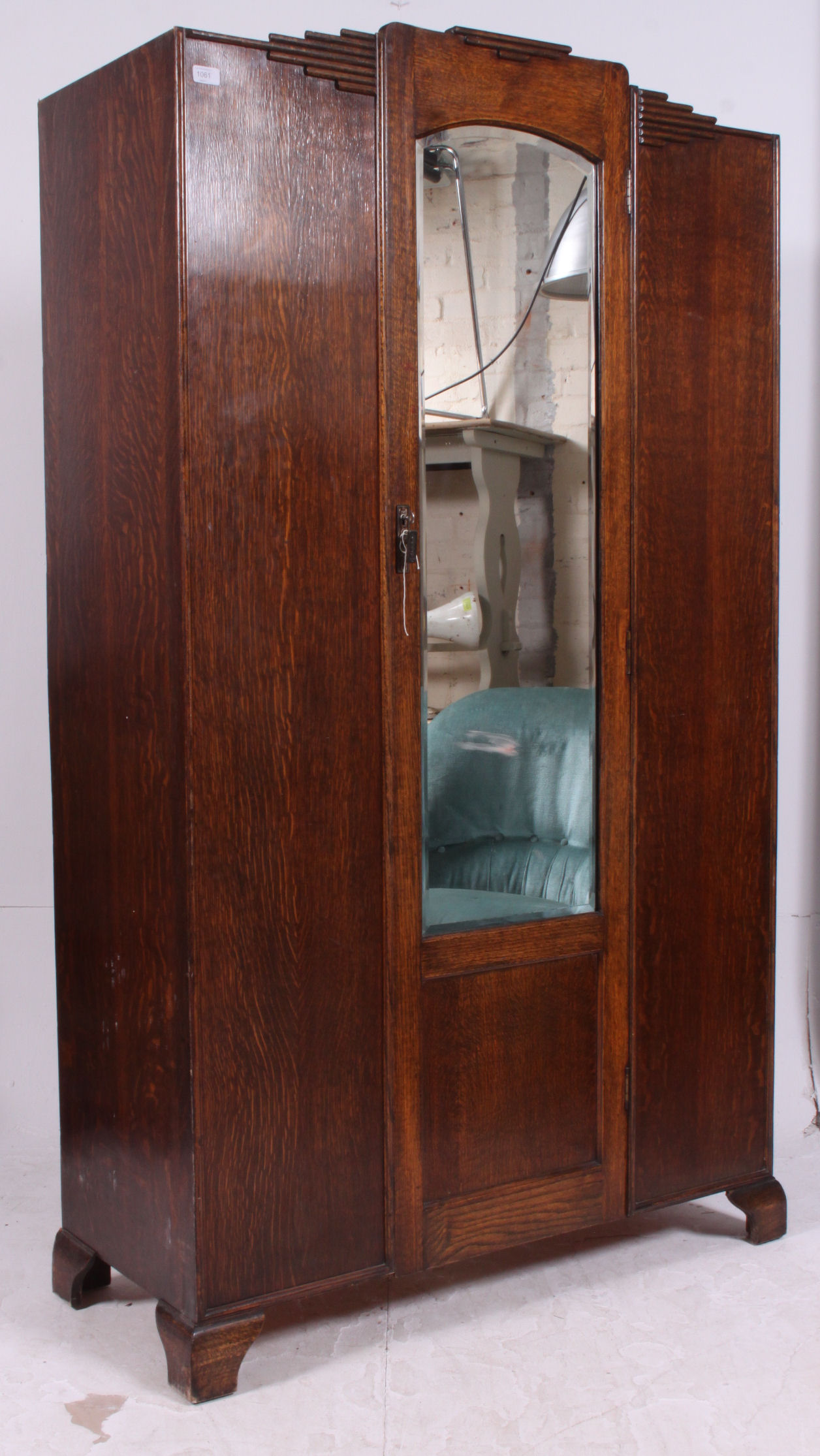 A 1930's Art Deco oak single wardrobe having shaped top with central mirror door having hanging