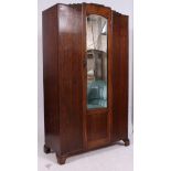 A 1930's Art Deco oak single wardrobe having shaped top with central mirror door having hanging