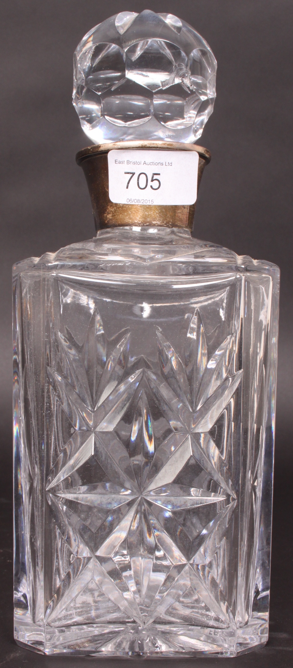 A cut glass decanter with stopper having a silver hallmarked silver collar