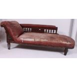 A Victorian oak and faux leather chaise longue sofa day bed raised on turned legs with spindle back