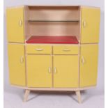A 1950's retro yellow and white two tone kitchen cabinet dresser with multiple drawers and shelves.