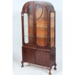 A 1930's Art Deco walnut veneer display cabinet raised on cabriole legs with pad feet having glass