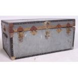 A vintage metal steamer trunk of usual form