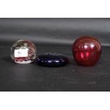 A Selkirk 1996 ' Firedance ' paperweight along with a Cranberry glass and blue glass Bristol