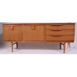 A retro 1970's Danish style teak wood low sideboard dresser raised on turned legs with a series of