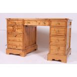 A 20th century antique style pine twin pedestal desk having drawers to each pedestal having flared