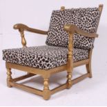A Shabby Chic Ercol painted gold and leopard skin upholstered armchair.