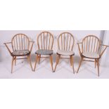 A set of 4 1970's vintage Ercol hoop back dining chairs raised on turned legs with panel seats and