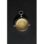 A silver hallmarked coin fob with enamel painted crest to verso.