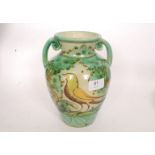 A decorative continental faience twin handled vase having exotic bird motif.