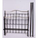 An Edwardian cast iron double bed with squared supports having rococo styled top rail with bed