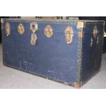 A vintage large steamer trunk with hinged top and clasps to front having brass bound corners etc