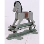 A 1950's scratchbuilt painted wooden rocking horse in grey with saddle and glider base