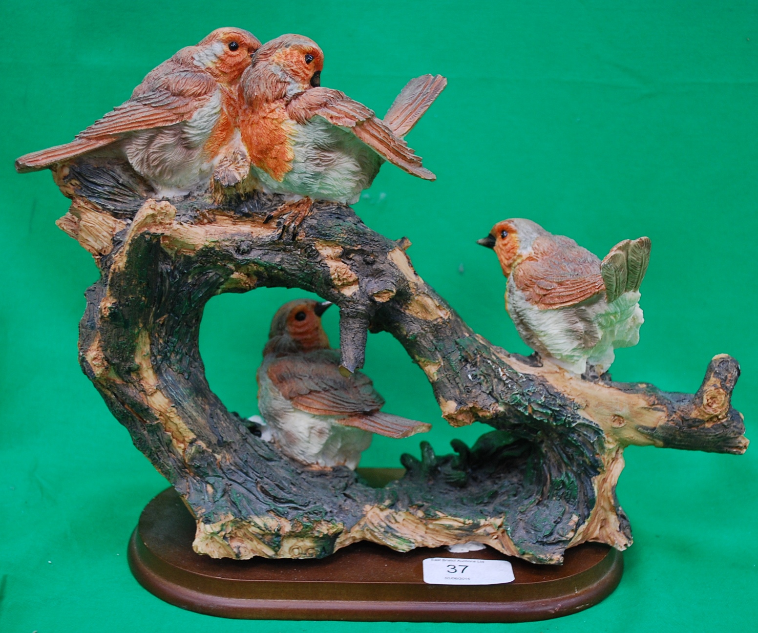 A group of 4 porcelain robins on a wood