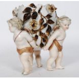 A 19th century Dresden / continental porcelain centrepiece depicting three cherubs holding up a